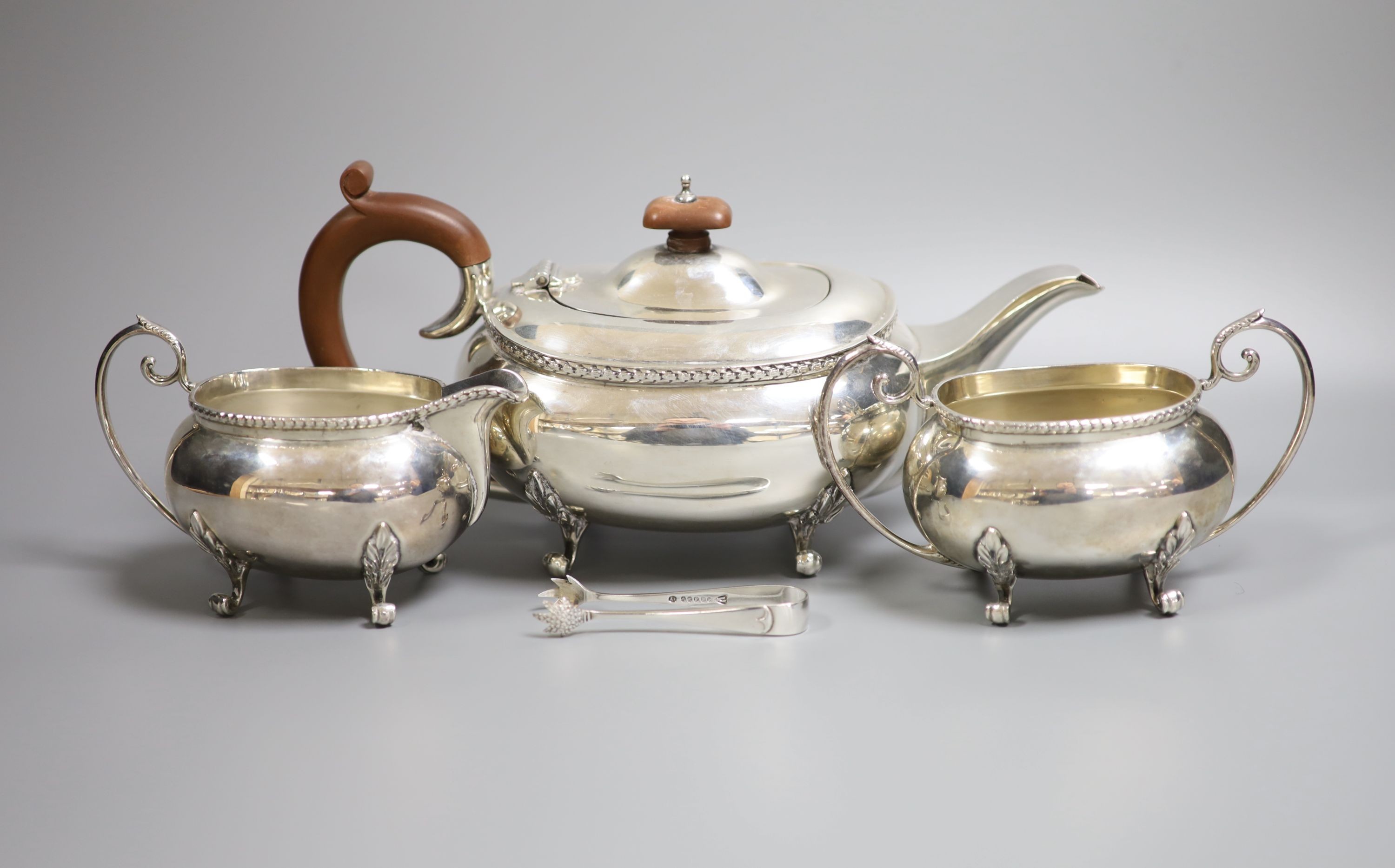 A modern silver three piece tea set by Joseph Gloster Ltd, Birmingham, 1974, gross weight 33oz and a pair of plated sugar tongs.